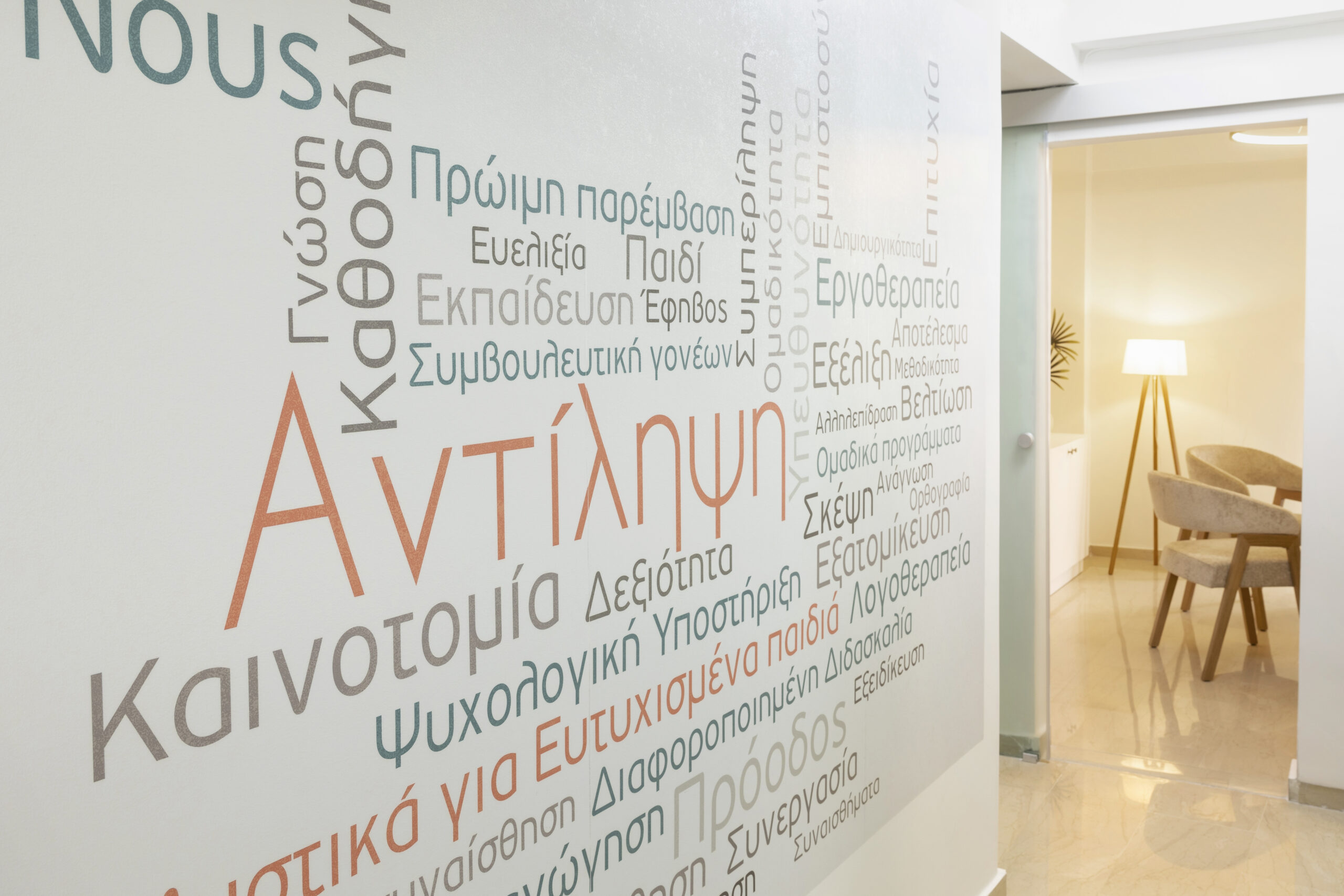 Γραφείο φιλολόγου και υπεύθυνης κέντρου ειδικής αγωγής με διακοσμητική ταπετσαρία εκπαιδευτικών εννοιών.